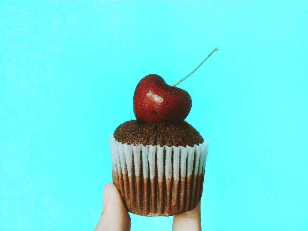 One product store - a hand holds a single cupcake with a cherry