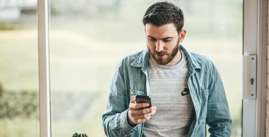 online verkaufen: Mann schaut auf Handy