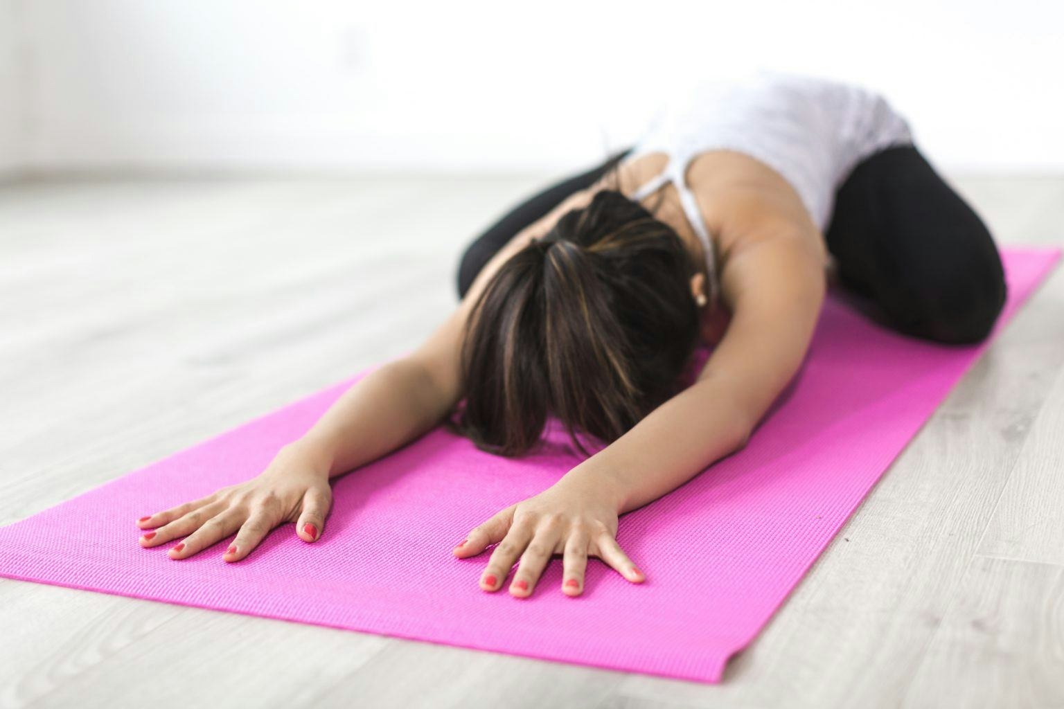 Frau dehnt auf Yogamatte