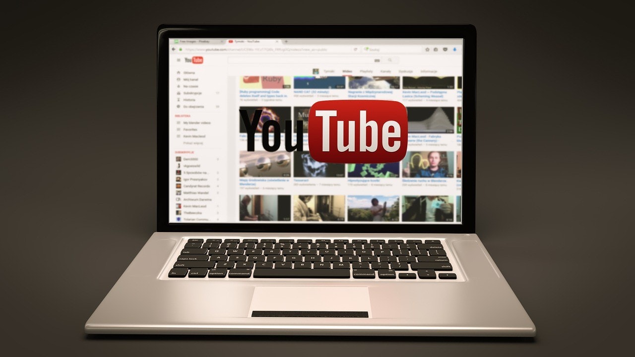 Silver laptop open with YouTube home page displayed
