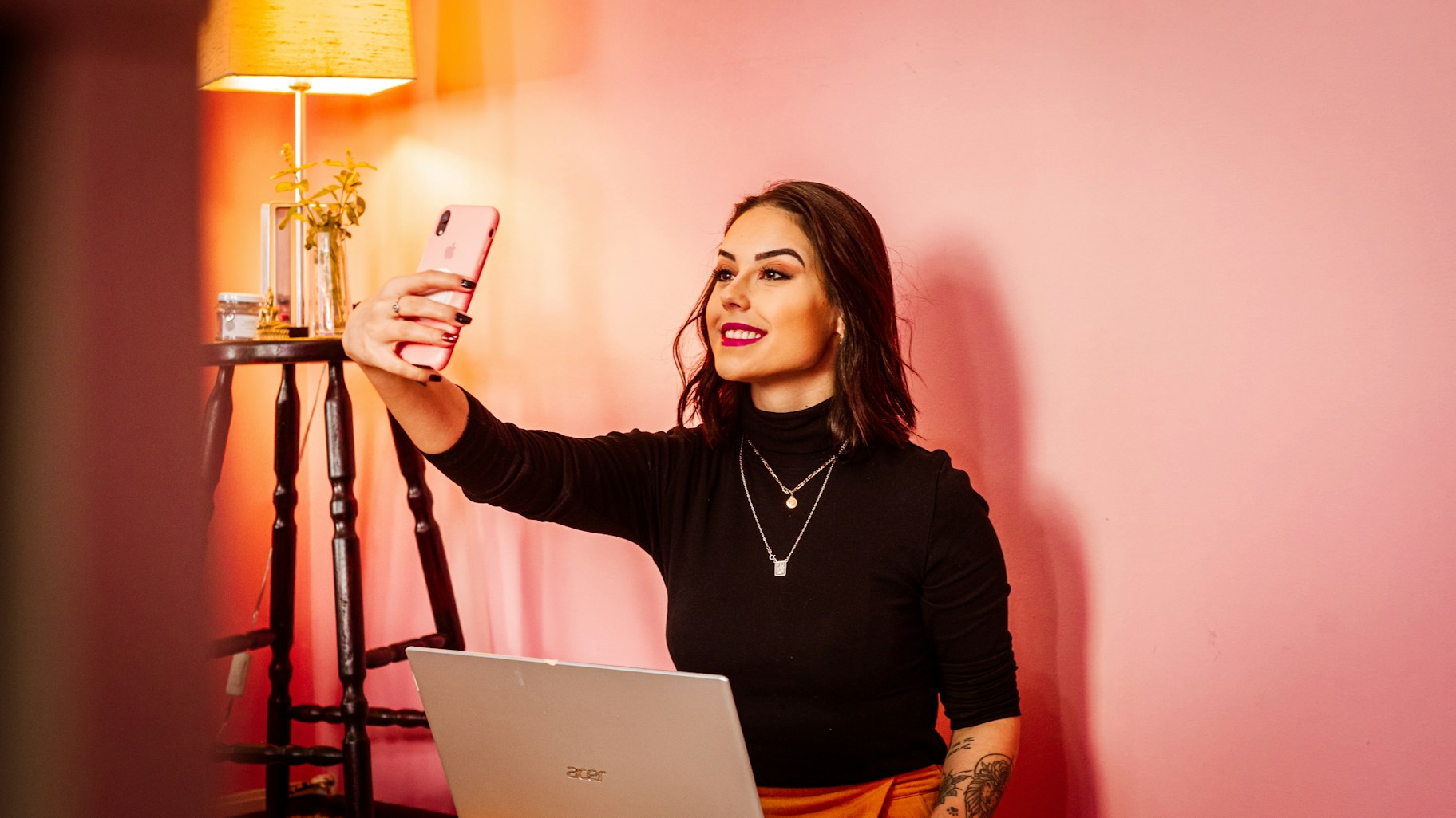 Geld verdienen auf Instagram als Influencer - Frau macht Selfie vor ihrem Laptop
